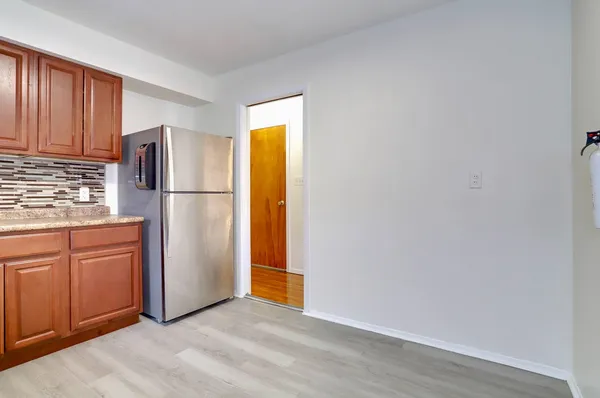 a view of kitchen with refrigerator cabinets and wooden floor