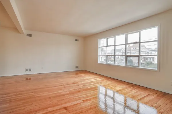 wooden floor in an empty room with a window