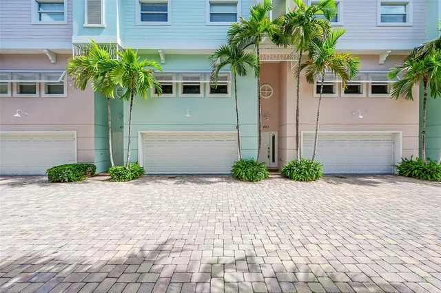 a front view of a house with a yard and potted plants