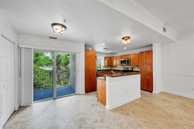 a kitchen with granite countertop wooden cabinets stainless steel appliances and a window