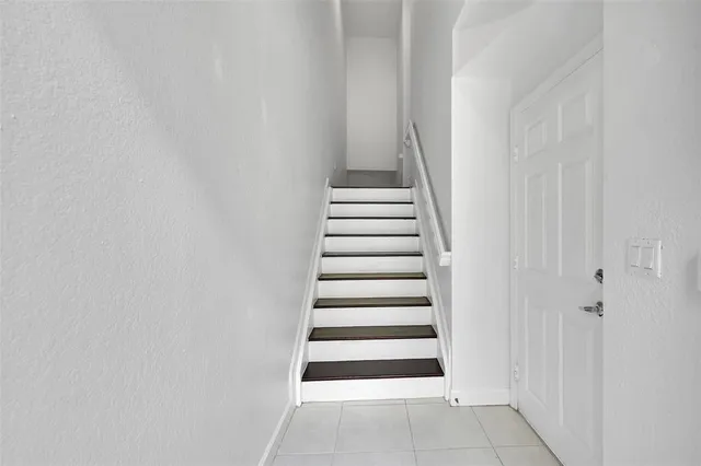 an empty room with white walls and ceiling fan