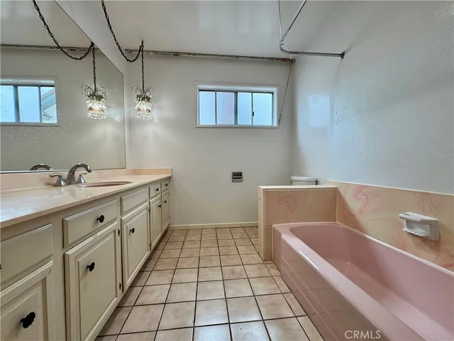 a bathroom with a tub sink and mirror