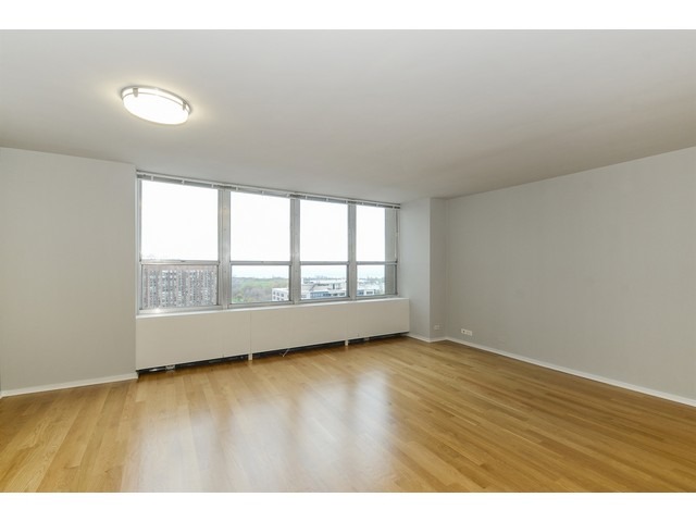 655 West Irving Park Road, Unit 2508 Chicago, IL 60613 - Photo 4 of 20 a view of an empty room with wooden floor and a window