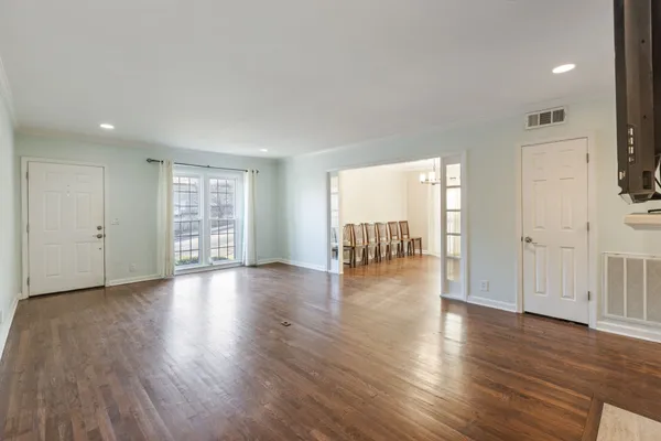 a view of empty room with wooden floor and a fireplace