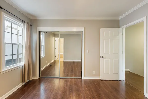 a view of an empty room with wooden floor