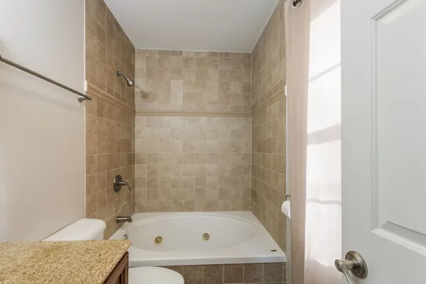 a view of a big room with wooden floor and a bathroom