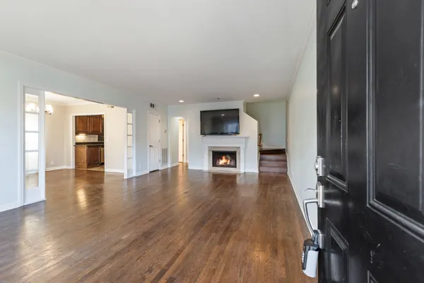 a view of empty room with wooden floor and window