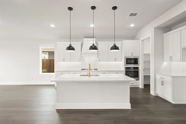 a kitchen with kitchen island a sink a stove and center island