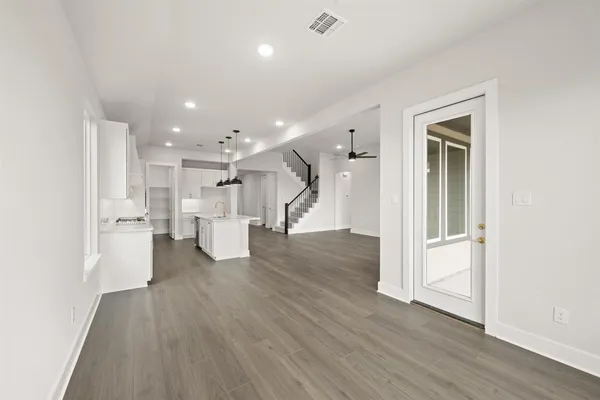 a view of a big room with wooden floor and windows