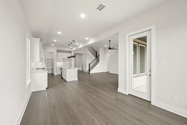 a view of a big room with wooden floor and windows