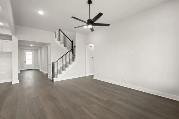 a view of a hallway with wooden floor and white walls