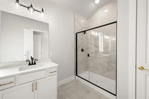 a bathroom with a shower sink and mirror