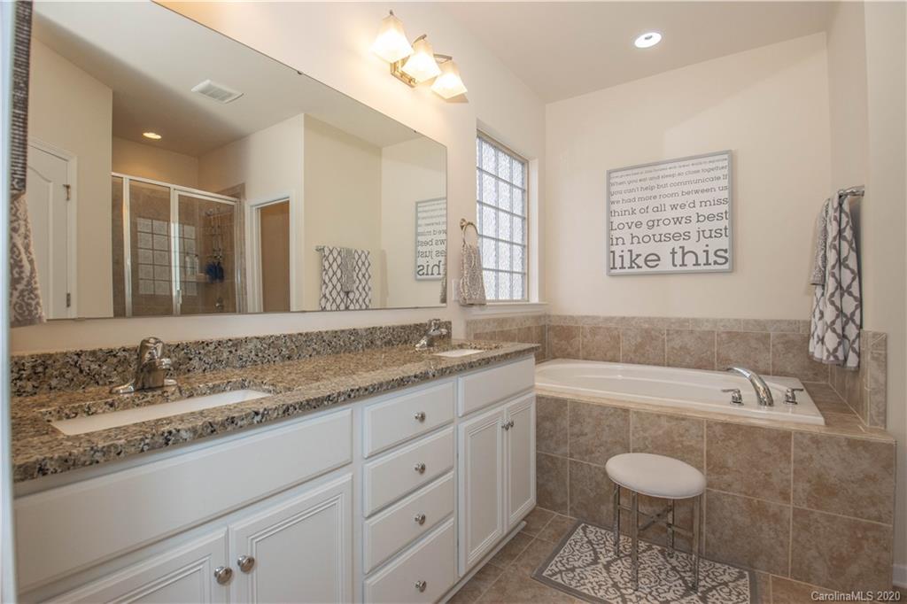 5149 Waterloo Drive Tega Cay, SC 29708 - Photo 15 of 28 a bathroom with a granite countertop sink and a bathtub