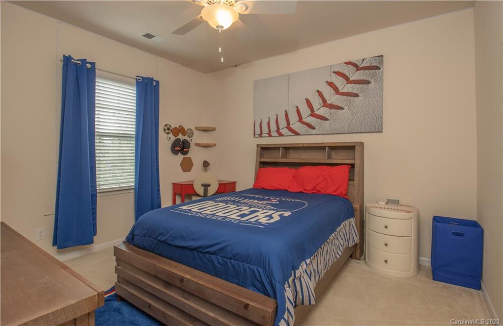 5149 Waterloo Drive Tega Cay, SC 29708 - Photo 19 of 28 a bedroom with a bed and a chandelier