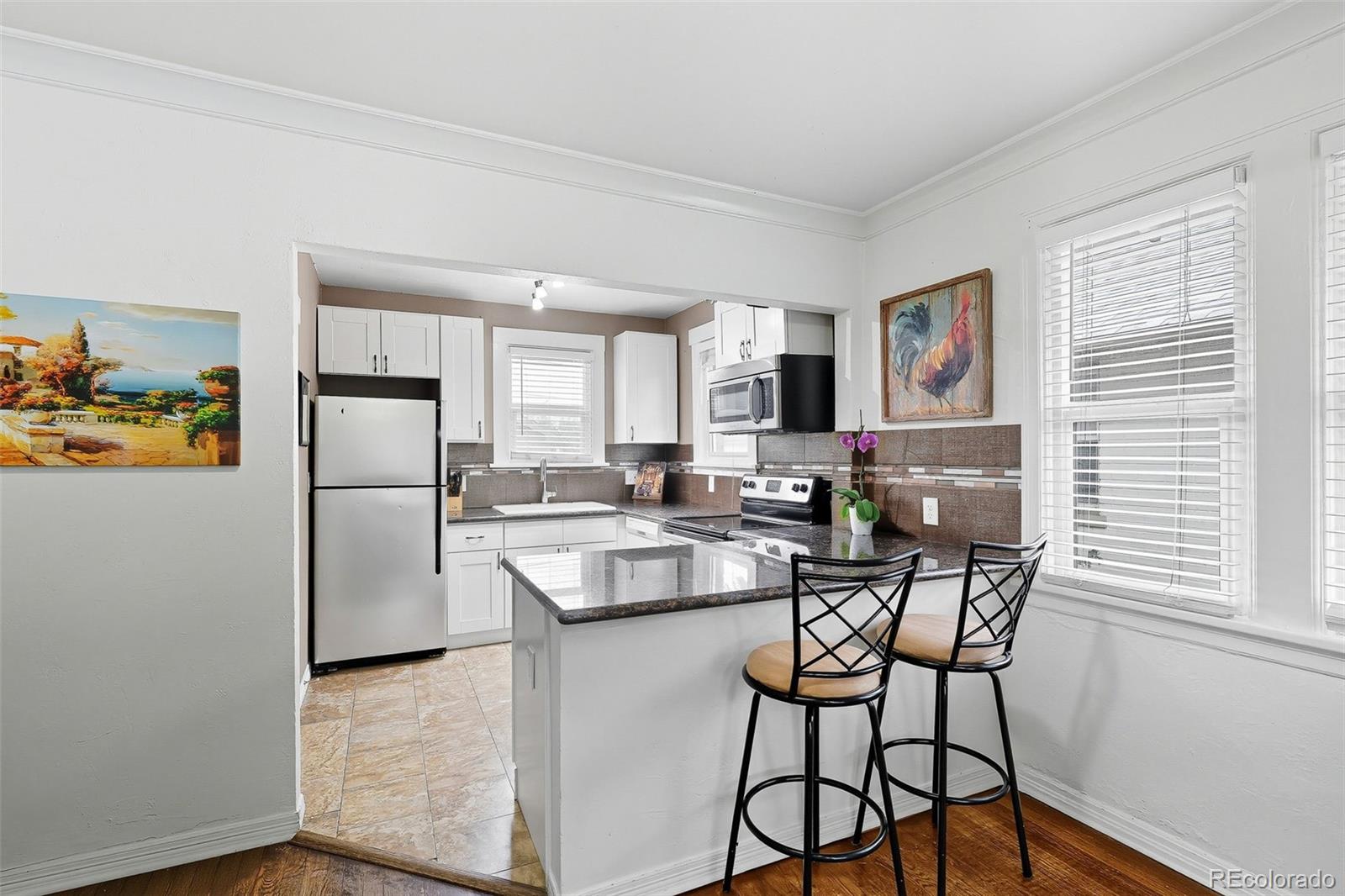 1280 Harrison Street Denver, CO 80206 - Photo 15 of 50 a kitchen with stainless steel appliances granite countertop a dining table chairs refrigerator and sink