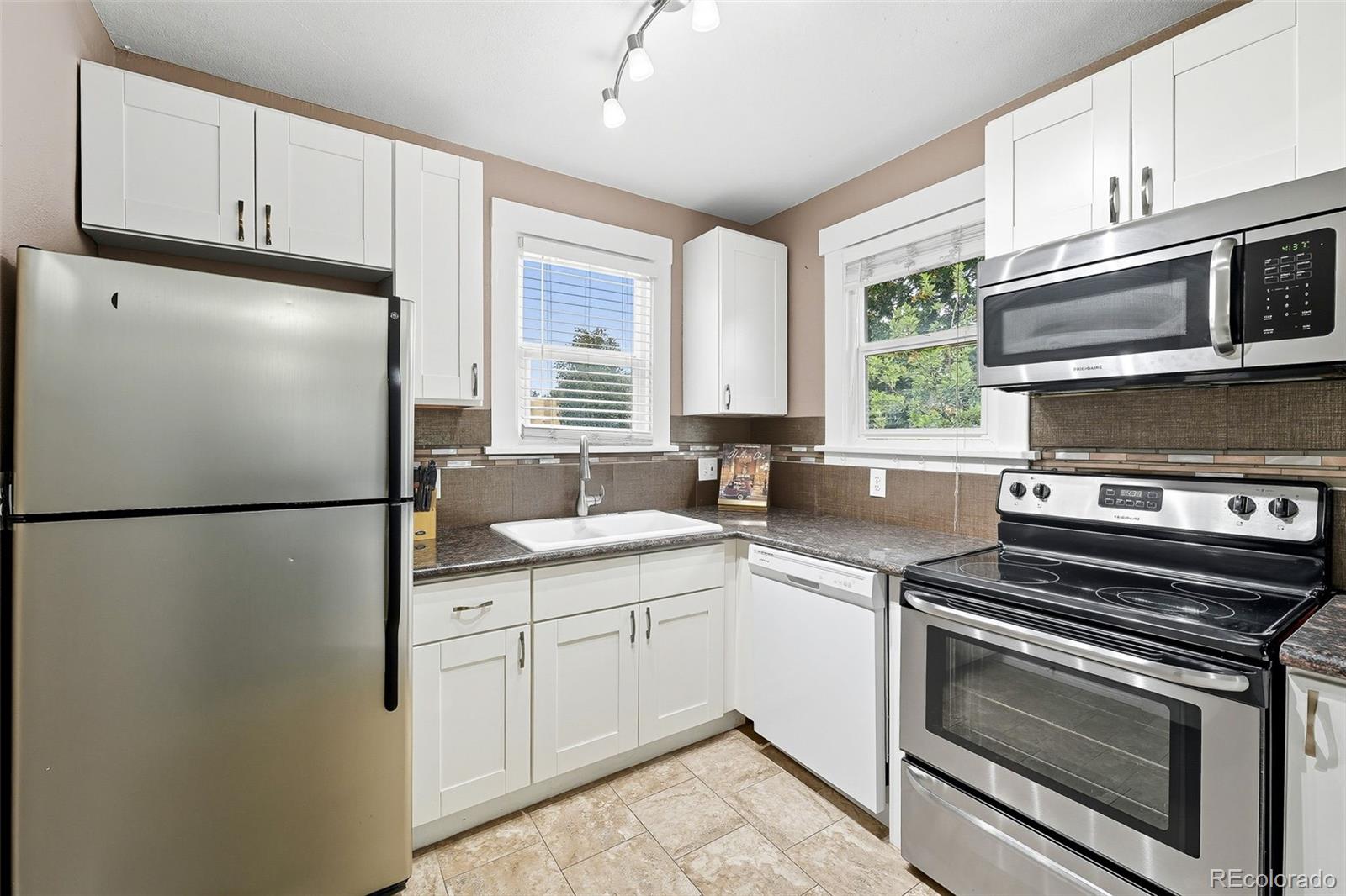 1280 Harrison Street Denver, CO 80206 - Photo 18 of 50 a kitchen with a refrigerator sink and window