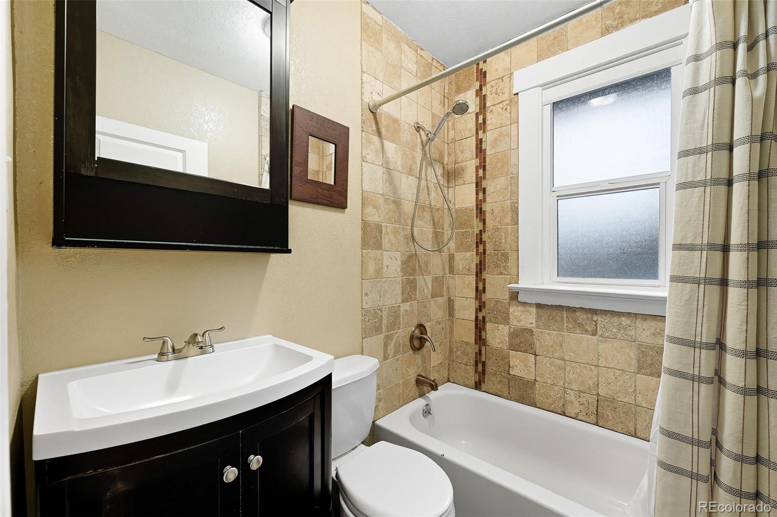1280 Harrison Street Denver, CO 80206 - Photo 27 of 50 a bathroom with a sink a toilet a mirror and shower