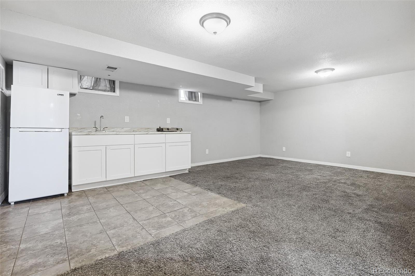 1280 Harrison Street Denver, CO 80206 - Photo 29 of 50 a kitchen with white cabinets and white appliances