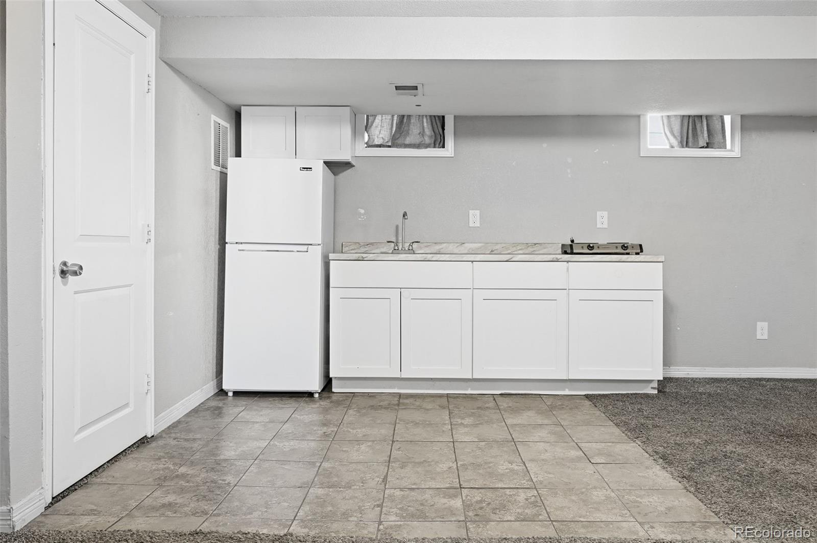 1280 Harrison Street Denver, CO 80206 - Photo 30 of 50 a kitchen with a stove a refrigerator and a sink