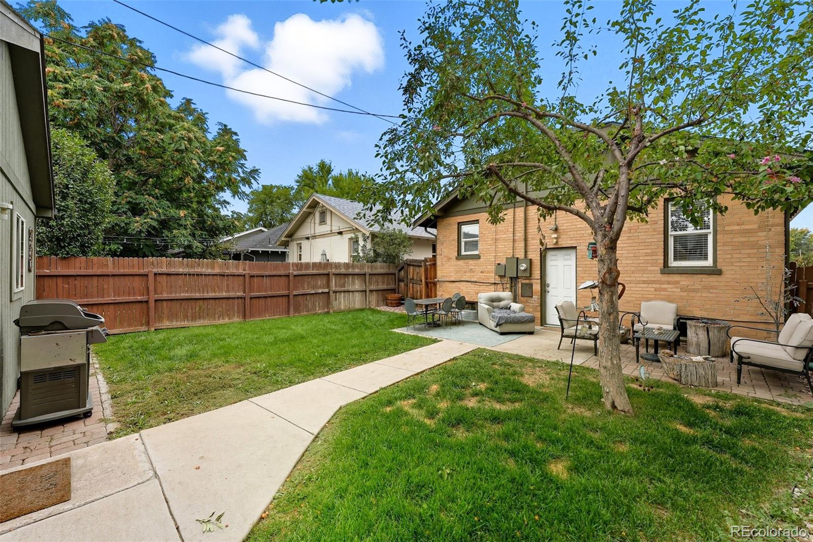 1280 Harrison Street Denver, CO 80206 - Photo 39 of 50 a view of backyard of house with outdoor seating and green bushes