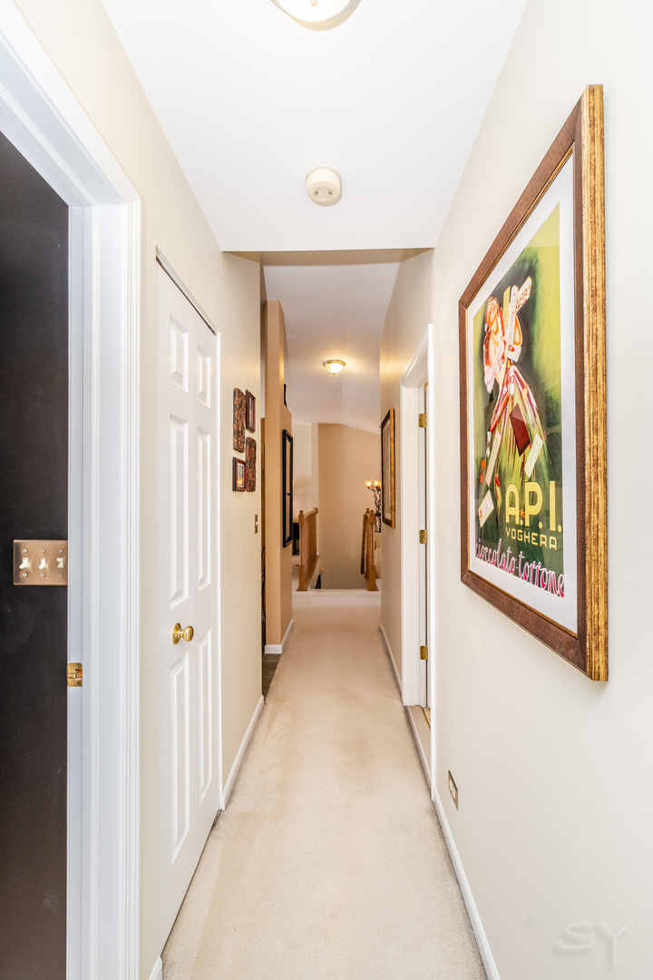 274 Wildspring Court Itasca, IL 60143 - Photo 27 of 42 a view of a hallway with a painting on the wall
