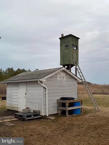 a view of a small house with a wooden deck
