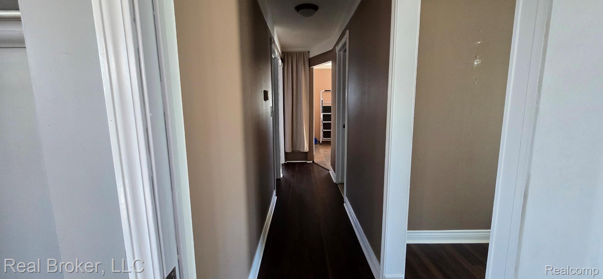 23401 Filmore Street Taylor, MI 48180 - Photo 7 of 16 Hallway featuring wood-finish flooring, neutral wall tones, white trim, and a flush mount ceiling light