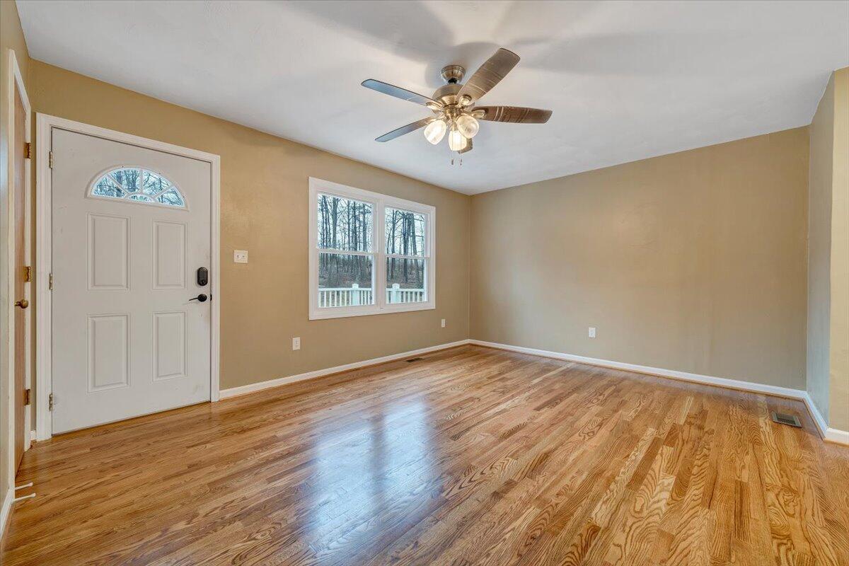 5146 Keffer Road Catawba, VA 24070 - Photo 7 of 43 a view of an empty room with wooden floor and a ceiling fan