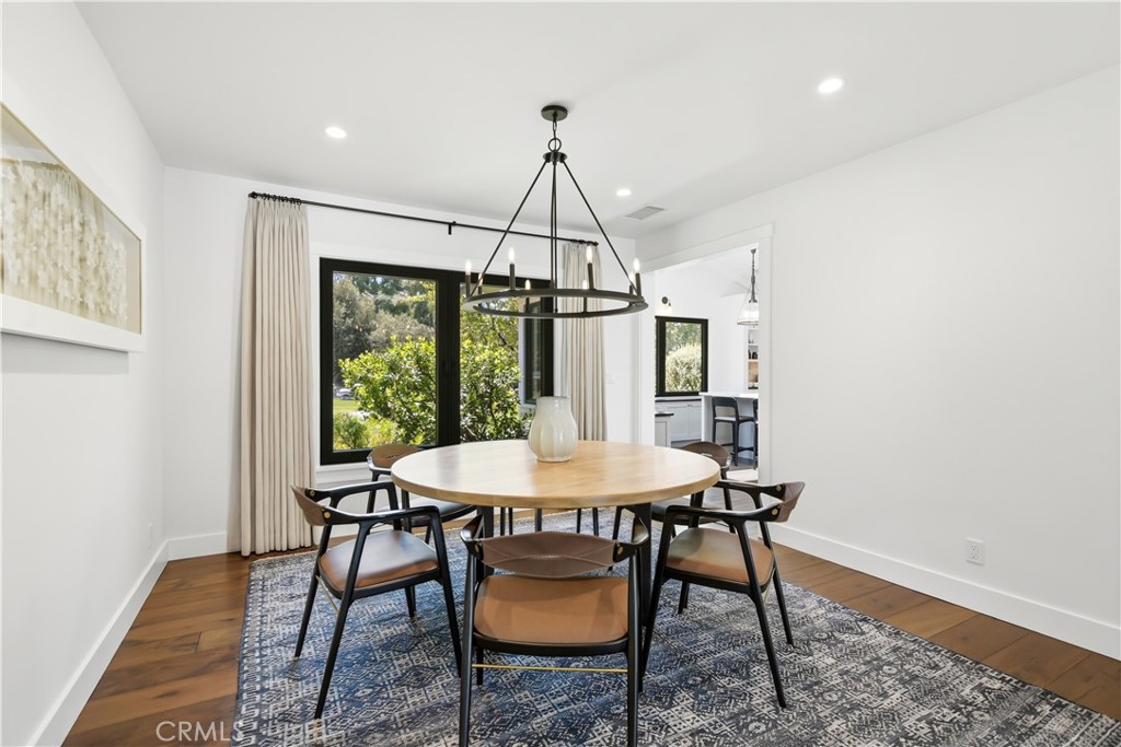 24884 Jim Bridger Road Hidden Hills, CA 91302 - Photo 9 of 31 a dining room with furniture a chandelier and wooden floor