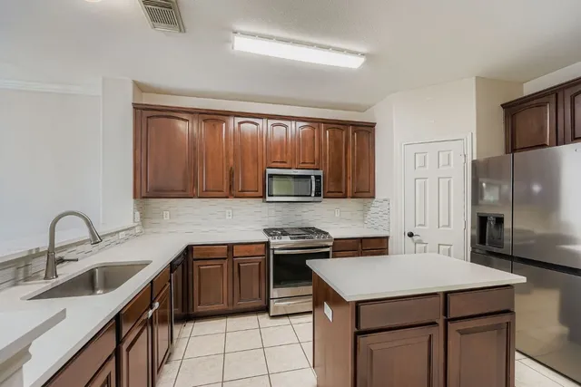 a kitchen with stainless steel appliances a refrigerator and a stove