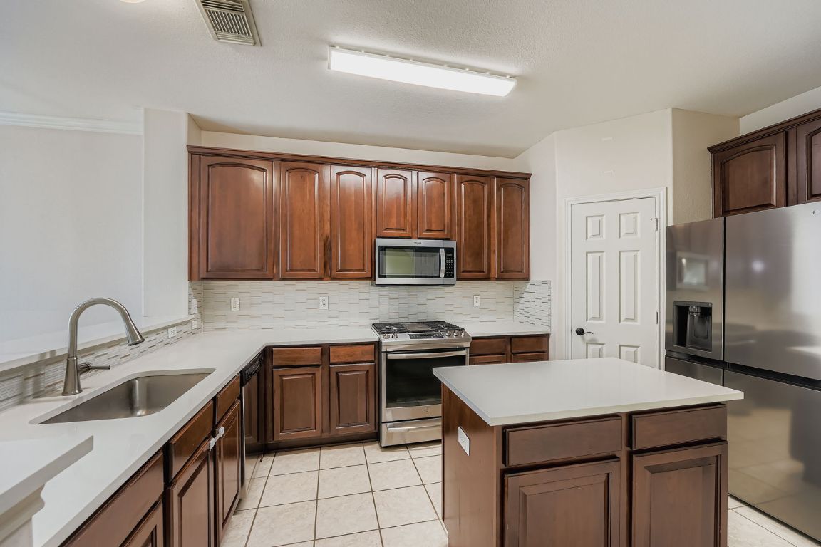 1101 East Parmer Lane, Unit 305 Austin, TX 78753 - Photo 11 of 37 a kitchen with a stove sink and cabinets