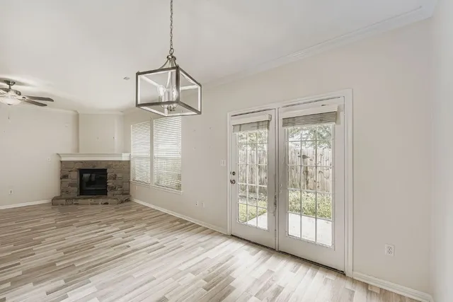 an empty room with windows and fan