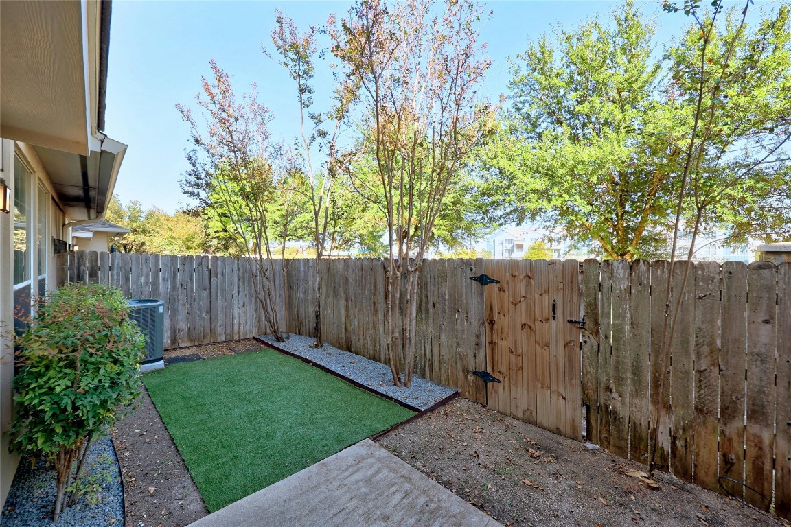 1101 East Parmer Lane, Unit 305 Austin, TX 78753 - Photo 29 of 37 a view of a backyard with wooden fence and a large tree
