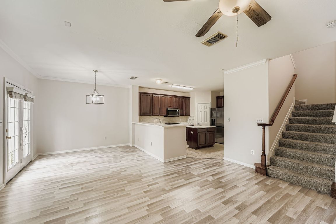 1101 East Parmer Lane, Unit 305 Austin, TX 78753 - Photo 10 of 37 a view of a kitchen with a sink and dishwasher a refrigerator with wooden floor