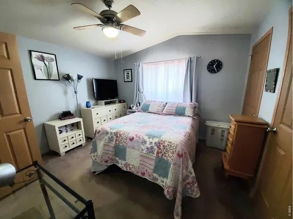 a bedroom with a bed and a flat tv screen on the dresser