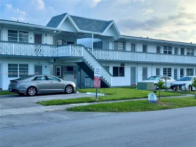 a front view of a residential apartment building with a yard