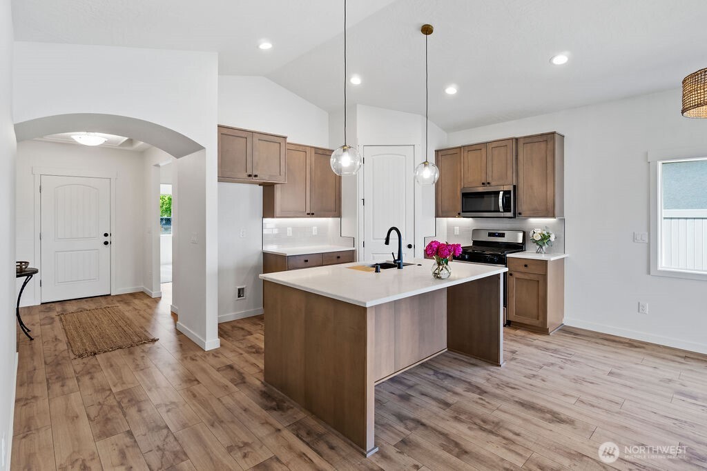 231 Shrute Road Prosser, WA 99350 - Photo 8 of 36 a large kitchen with stainless steel appliances kitchen island granite countertop a stove a refrigerator a oven and a sink with wooden floor