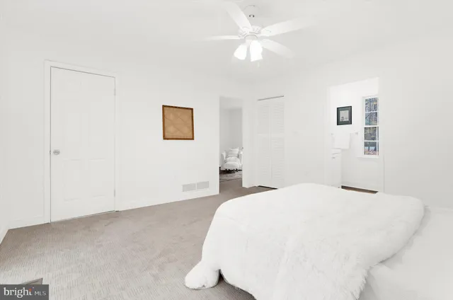 a spacious bedroom with a bed and a chandelier