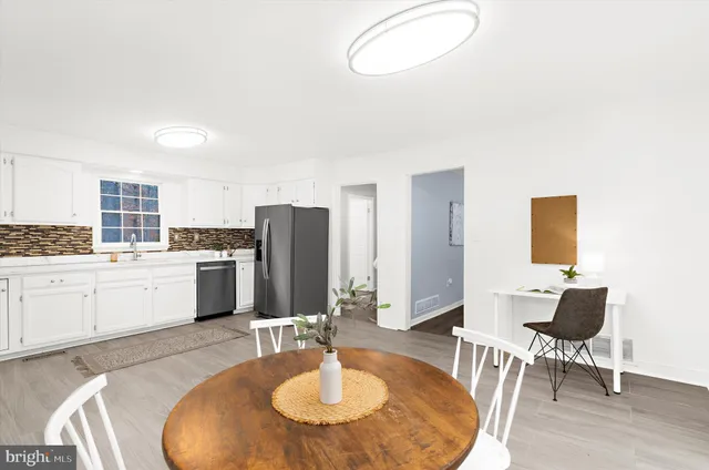 a open kitchen with stainless steel appliances kitchen island granite countertop a sink a stove a dining table and chairs