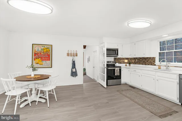 a kitchen with stainless steel appliances kitchen island granite countertop a table and chairs in it