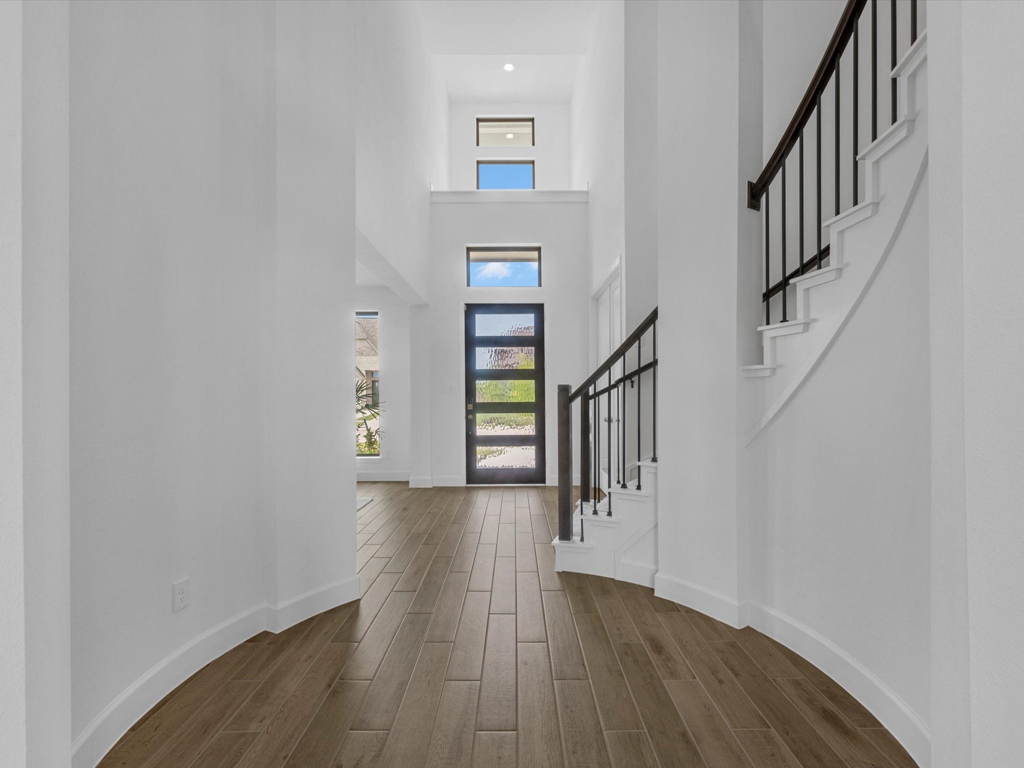 18714 Pistachio Way Manvel, TX 77578 - Photo 6 of 48 The elegant curved staircase offers a stunning architectural focal point, overlooking a sun-drenched foyer that sets the tone for the timeless design found throughout the home.
