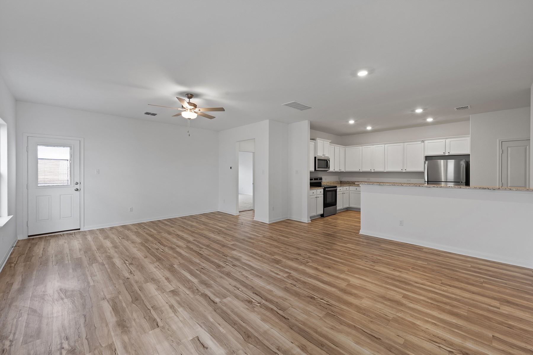 14609 Wahlbergs Way Elgin, TX 78621 - Photo 2 of 11 a view of a kitchen with a microwave and a stove