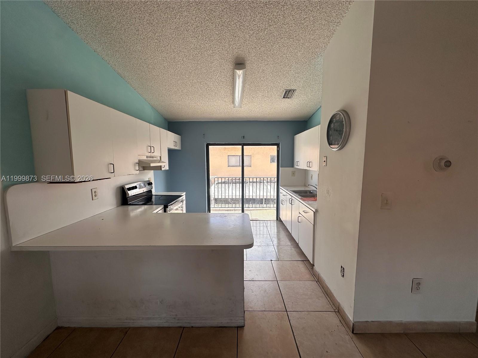 7952 West 29th Way, Unit 202 Hialeah, FL 33018 - Photo 2 of 12 a large white kitchen with a large window