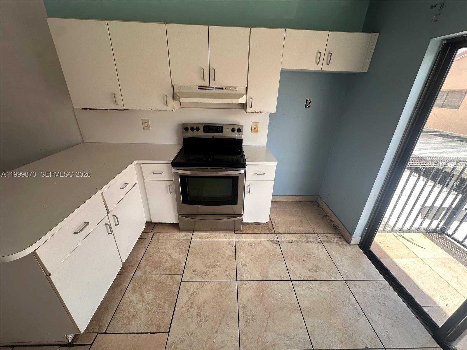 7952 West 29th Way, Unit 202 Hialeah, FL 33018 - Photo 3 of 12 a kitchen with a stove a sink and a window