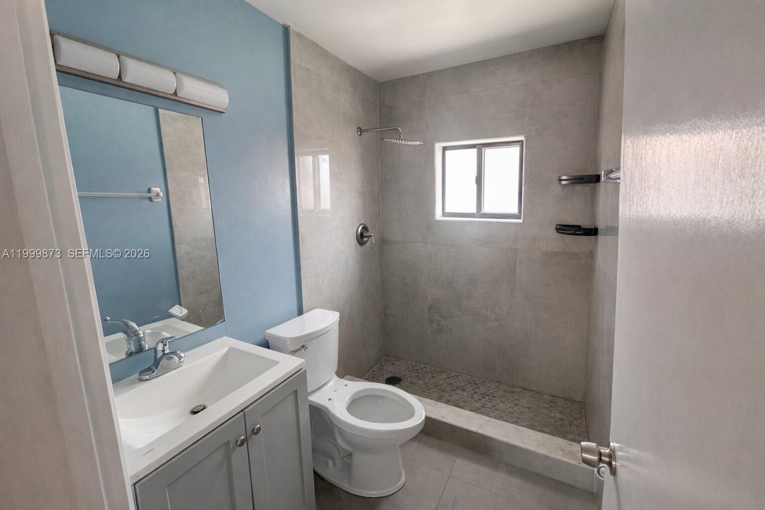 7952 West 29th Way, Unit 202 Hialeah, FL 33018 - Photo 5 of 12 a bathroom with a shower sink vanity and toilet