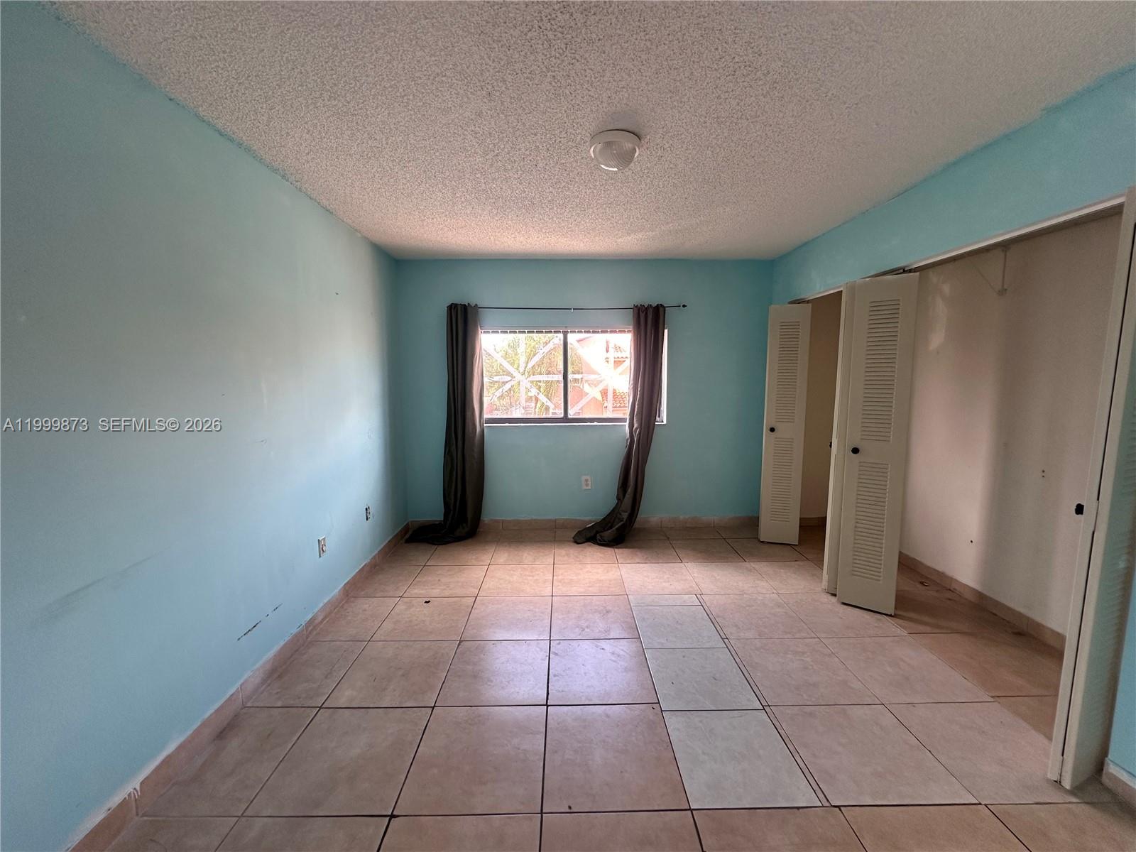 7952 West 29th Way, Unit 202 Hialeah, FL 33018 - Photo 8 of 12 a view of an empty room with window and bathroom