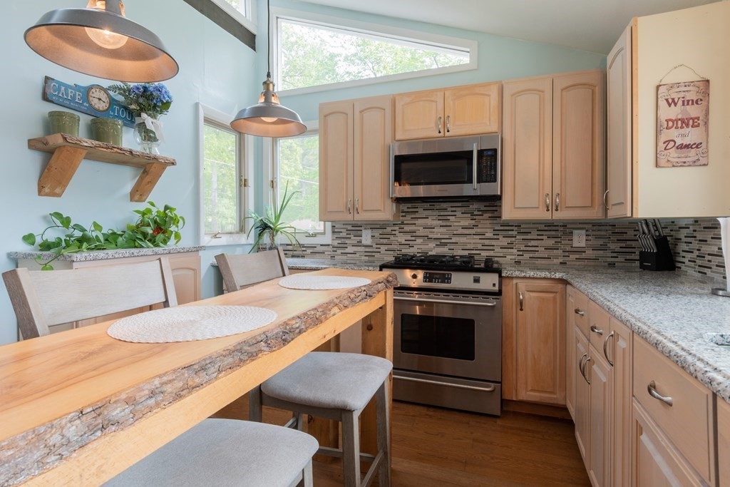 7 Sunset Drive Merrimack, NH 03054 - Photo 11 of 35 a kitchen with stainless steel appliances granite countertop a stove a sink dishwasher and microwave with wooden floor