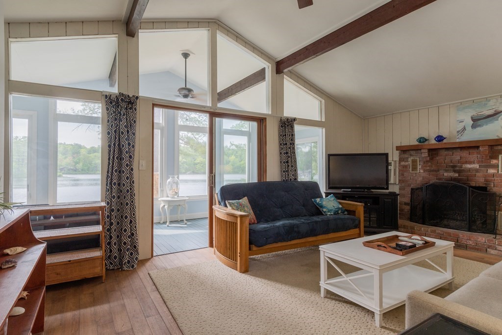 7 Sunset Drive Merrimack, NH 03054 - Photo 12 of 35 a living room with furniture a flat screen tv and a floor to ceiling window