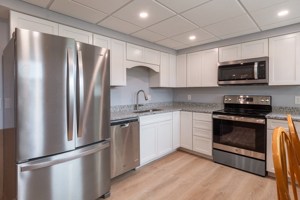 7 Sunset Drive Merrimack, NH 03054 - Photo 18 of 35 a kitchen with stainless steel appliances granite countertop a refrigerator stove a sink and a microwave