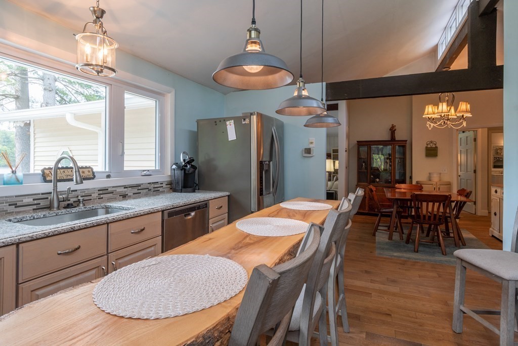 7 Sunset Drive Merrimack, NH 03054 - Photo 10 of 35 a kitchen with stainless steel appliances granite countertop a sink a stove a dining table and chairs